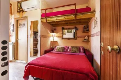 a bedroom with a bed with a red bedspread at Casa Bella B&B 2 Unità - Una con bagno privato oppure camera con bagno condiviso in Rome