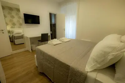 a bedroom with a bed and a desk and a television at Suite Pinturicchio in Rome