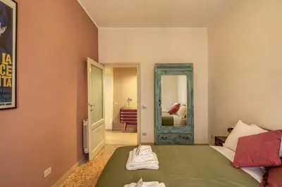 a bedroom with a green bed and a mirror at Trastevere San Cosimato vintage in Rome