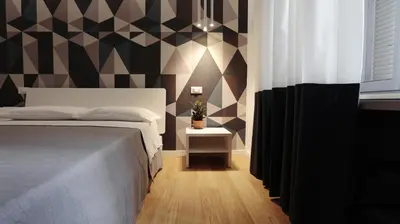 a bedroom with a bed and a geometric wall at Suite Inn Rome in Rome