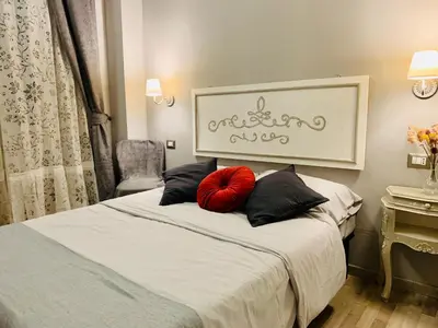 a bedroom with a bed with a red pillow on it at ISABEL Guest House in Rome