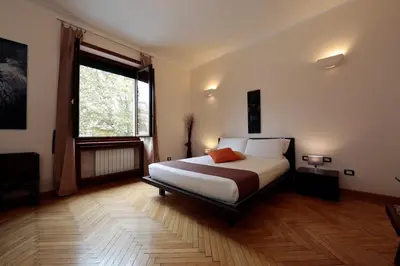 a bedroom with a bed and a large window at Residenza Delle Arti in Rome
