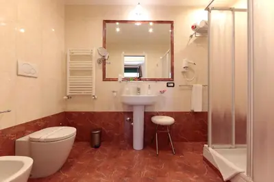 a bathroom with a sink and a toilet and a mirror at Residenza Delle Arti in Rome