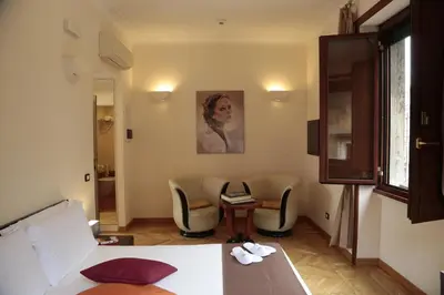 a room with a bed and chairs and a table at Residenza Delle Arti in Rome
