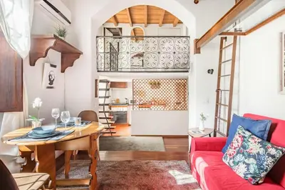 a living room with a red couch and a table at Trastevere Alley Apartment in Rome