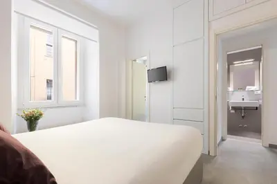 a white bedroom with a bed and a sink at ROMAC Villa Borghese with 3 bedrooms near Via Veneto in Rome