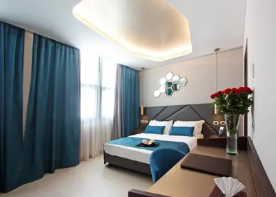 a bedroom with a blue bed and a table with flowers at The Hive Hotel in Rome