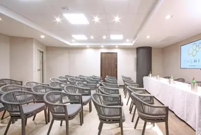 a row of chairs in a room with a long table at The Hive Hotel in Rome