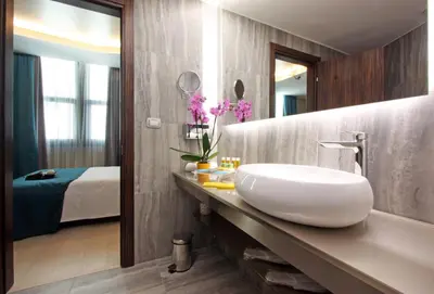 a bathroom with a white sink and a bedroom at The Hive Hotel in Rome
