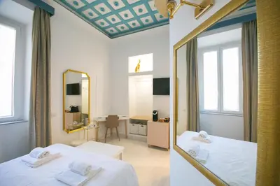 a room with two beds and a mirror in it at Caffe' e Cuscino in Rome