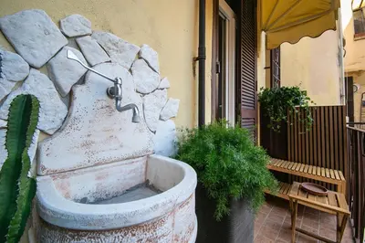 a stone water fountain in front of a building at Caffe' e Cuscino in Rome