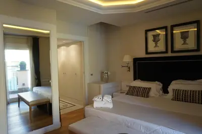a bedroom with a large white bed and a mirror at Trevi Palace Luxury Inn in Rome