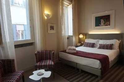 a hotel room with a bed and two chairs at Trevi Palace Luxury Inn in Rome