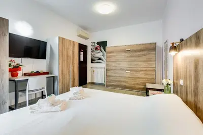 a bedroom with a large white bed and a desk at B&B Casa Der Poeta in Rome