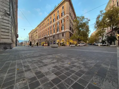 an empty city street with a large building at A casa di Alex Vatican in Rome