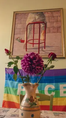 a vase with purple flowers in front of a painting at Casa ParticulART in Rome