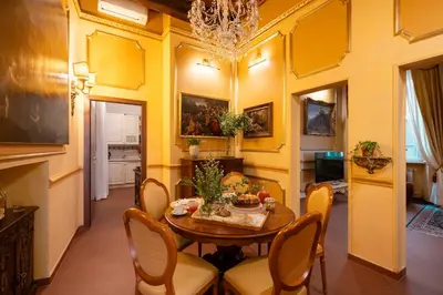 a dining room with yellow walls and a table and chairs at Antica dimora navona in Rome