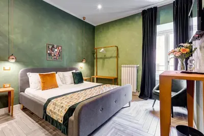 a bedroom with a bed in a room with green walls at Ripetta Natural Suites in Rome