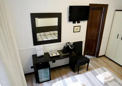 a room with a desk with a mirror and a chair at GH Colosseum in Rome