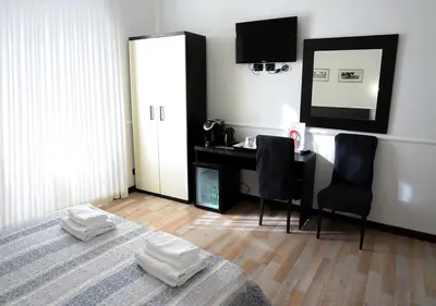 a bedroom with a bed with a desk and a mirror at GH Colosseum in Rome