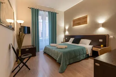 a bedroom with a bed with a green bedspread at Flowerome in Rome