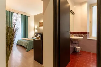 a bathroom with a sink and a bed in a room at Flowerome in Rome