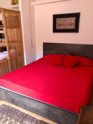 a red bed with red pillows in a bedroom at LeopardElla in Rome