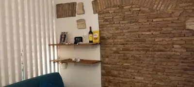 a room with a brick wall with two shelves at Domus next Campo de'Fiori with thermal shower in Rome
