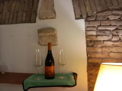 a bottle of wine sitting on a table with two glasses at Domus next Campo de'Fiori with thermal shower in Rome