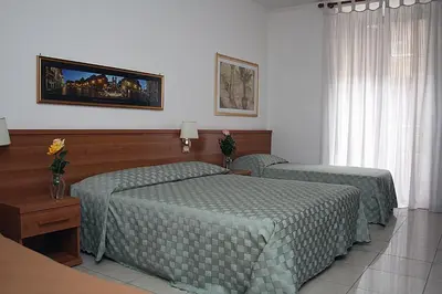 a bedroom with two beds with green comforters at Emanuela Guest House in Rome