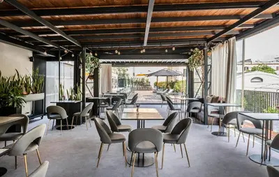 a restaurant with tables and chairs and windows at Horti 14 Borgo Trastevere Hotel in Rome