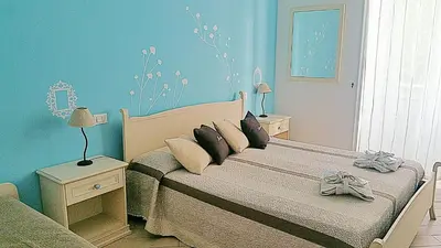 a blue bedroom with two beds and a couch at Il Mondo Di Amelia in Rome