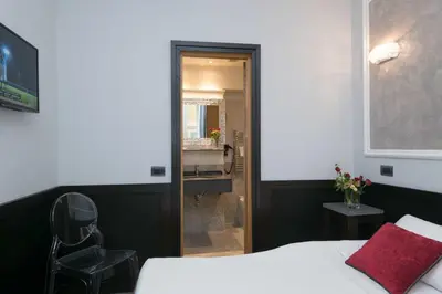 a bedroom with a bed and a chair and a mirror at DK Suites in Rome