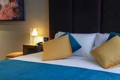 a bedroom with a bed with blue and white pillows at Triviho Hotel in Rome