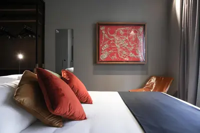 a bedroom with a bed with red pillows and a painting at Triviho Hotel in Rome