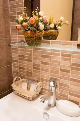 a bathroom sink with a basket of flowers on a mirror at Domus RomAntica in Rome