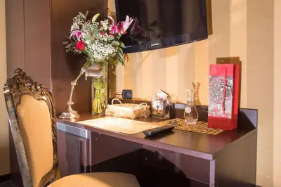 a desk with a vase of flowers on it at Domus RomAntica in Rome