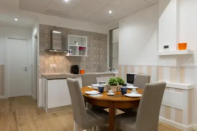 a kitchen and dining room with a wooden table and chairs at Domus St. John in Rome