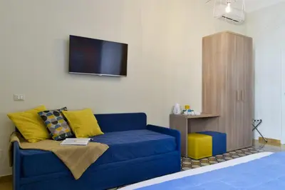 a living room with a blue couch and a tv at The Pope's Window in Rome