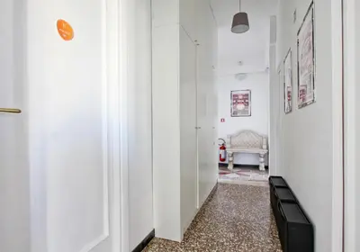 a hallway with white walls and a room with a couch at BigFamilyRome - San Giovanni Basilica in Rome