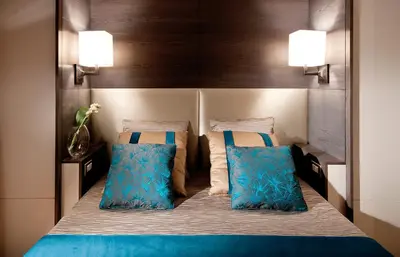 a bedroom with a bed with two blue pillows at San Carlo Suite in Rome