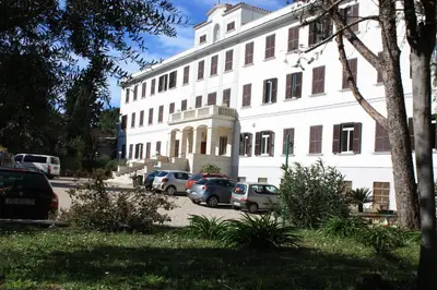 a white building with cars parked in front of it at Ostello Villa Monte Mario in Rome