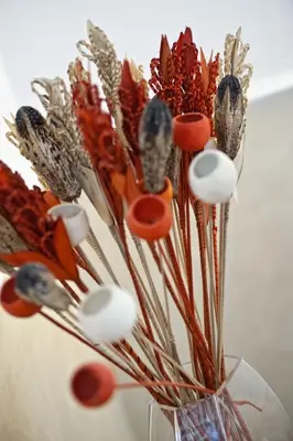 a glass vase filled with dried flowers and scissors at Romacentrarte in Rome