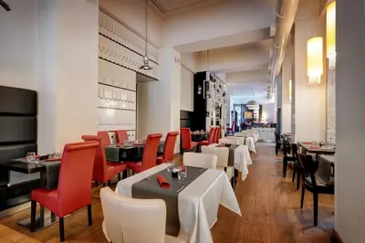 a restaurant with white tables and red chairs at Dharma Luxury Hotel & SPA in Rome
