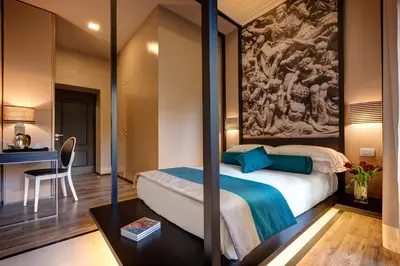 a bedroom with a bed with a painting on the wall at Dharma Luxury Hotel & SPA in Rome