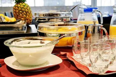 a table topped with glasses and a bowl of food at Dharma Luxury Hotel & SPA in Rome