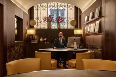 a man sitting at a table with a laptop at The First Arte - Preferred Hotels & Resorts in Rome