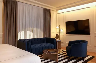 a hotel room with a bed and a couch and a tv at The First Arte - Preferred Hotels & Resorts in Rome