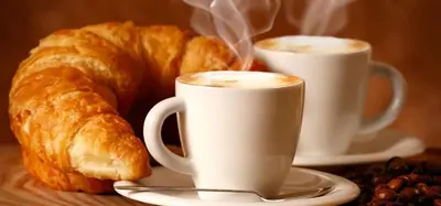 two cups of coffee and croissants on a table at Vatican Paradise in Rome