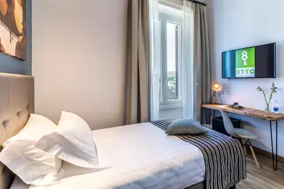 a bedroom with a bed and a desk and a window at OTTO Rooms & Photogallery in Rome